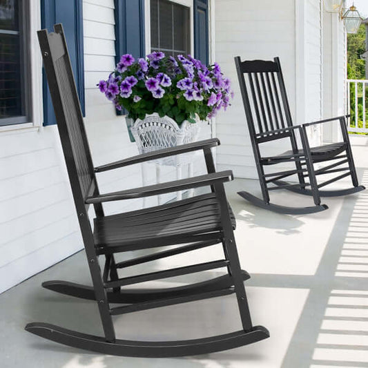 Wooden rocking chairs with armrests on a porch beside vibrant purple flowers, perfect for relaxing outdoors.