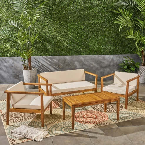 Stylish 4-seater acacia wood seating area with beige cushions and slatted coffee table, perfect for outdoor entertainment.