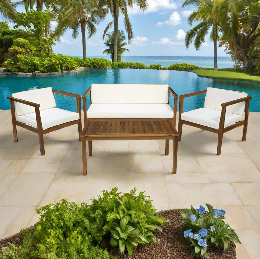 Elegant acacia wood outdoor seating set with plush white cushions and slatted coffee table by a serene poolside.