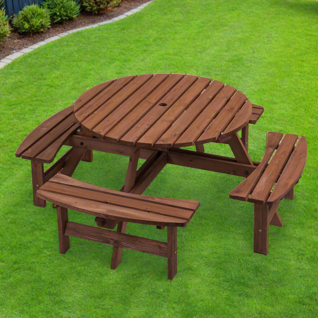 Circular wooden picnic table with benches on green grass for outdoor dining and gatherings.