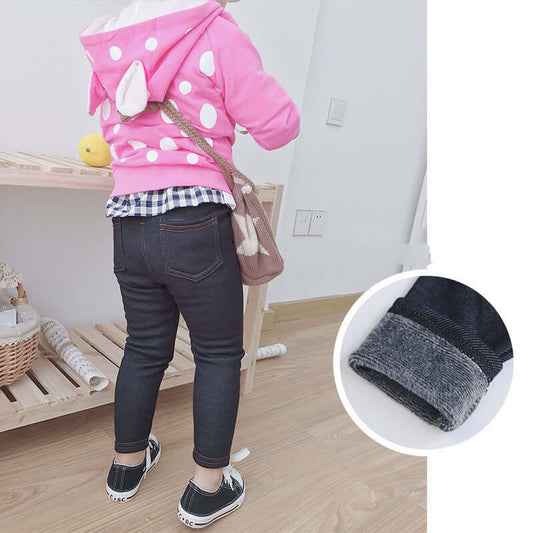 Child wearing pink polka-dot hoodie and jean leggings, showcasing stylish and comfy kids' outfit for playful adventures.