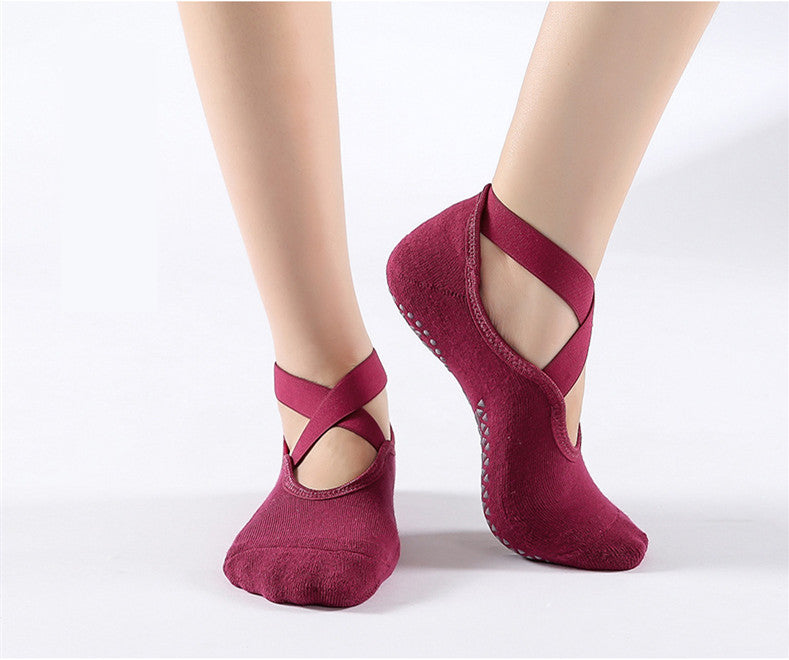 Red ballet-style dance socks with straps on a white background