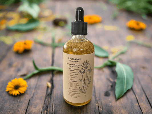 Bottle of 'Pure Essence' dry body oil on a wooden surface with flowers and leaves.