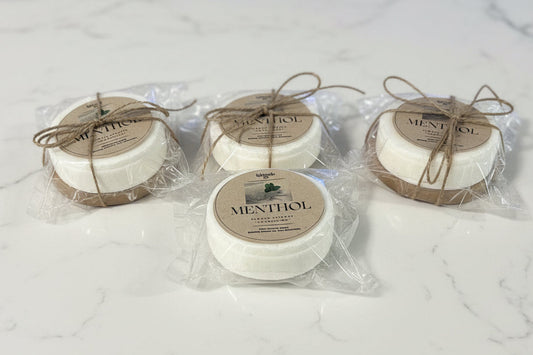 Four menthol products in clear packaging on a white marble surface