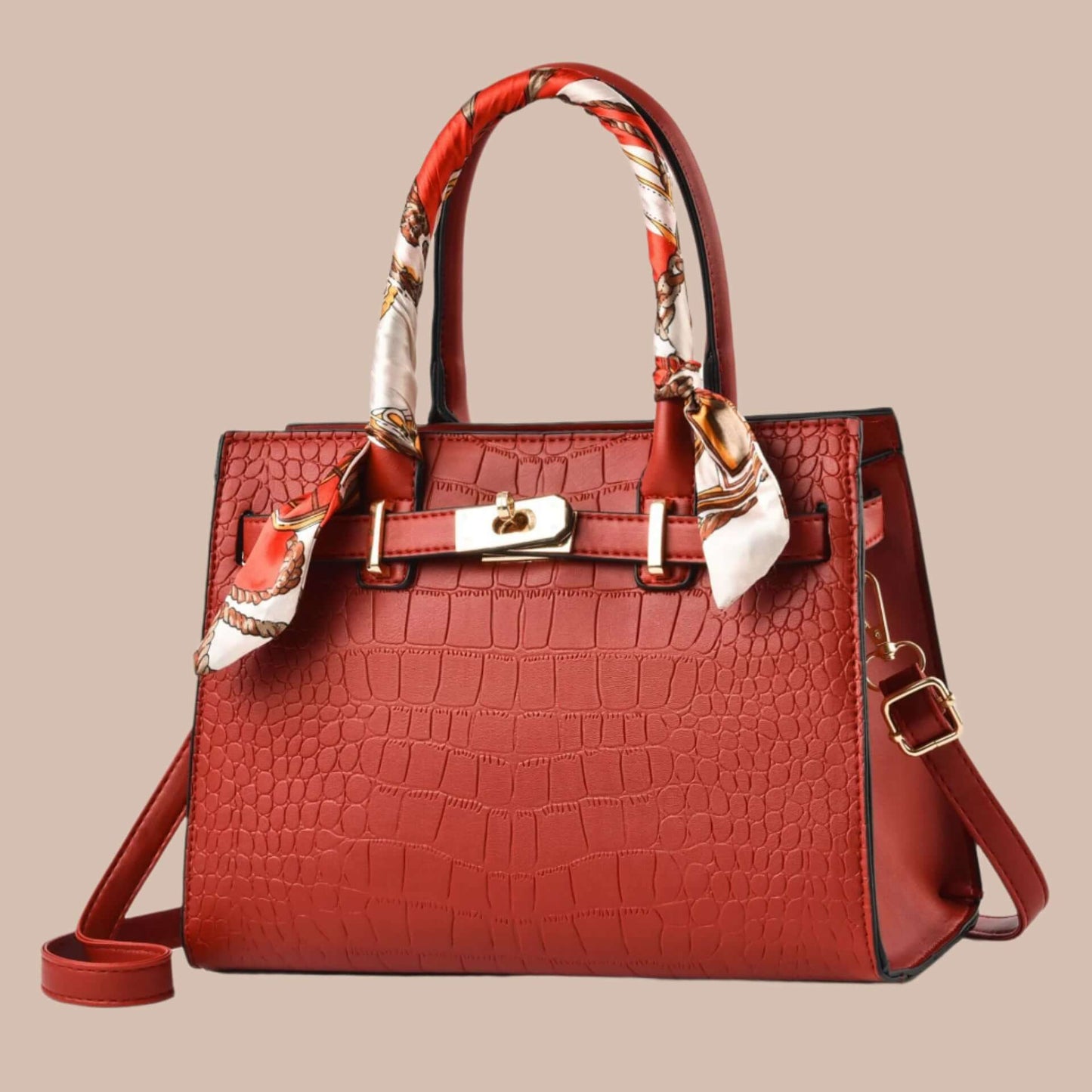 Red handbag with a patterned scarf on a white background