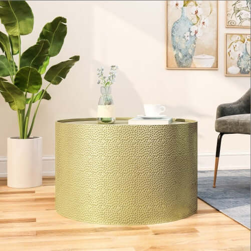 Hammered metal coffee table with a cylindrical design, featuring a chic metallic finish, suitable for modern decor.