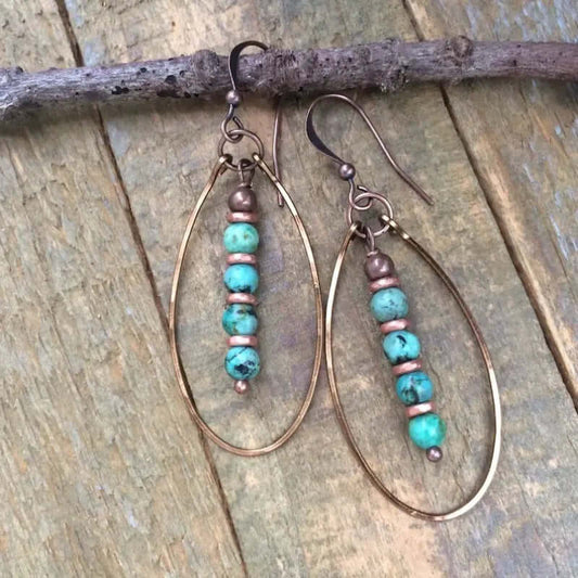 Women's Beaded Bohemian Vintage Earrings featuring turquoise blue stones and gold accents on a natural wood background.