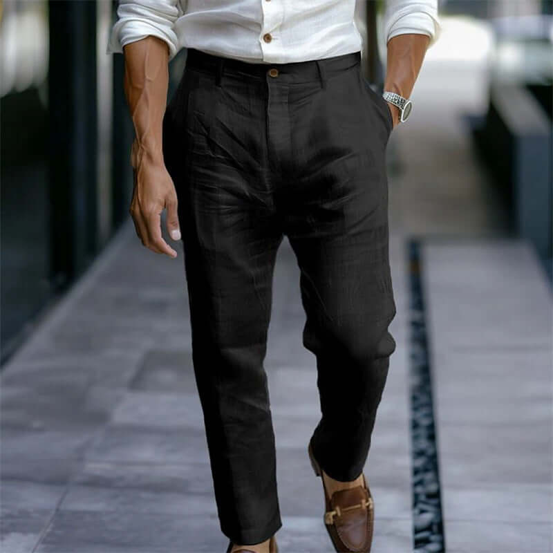 Person wearing black pants and a white shirt on a blurred street background