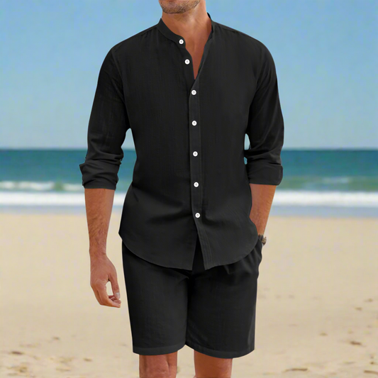 Man wearing a black shirt and shorts on a beach