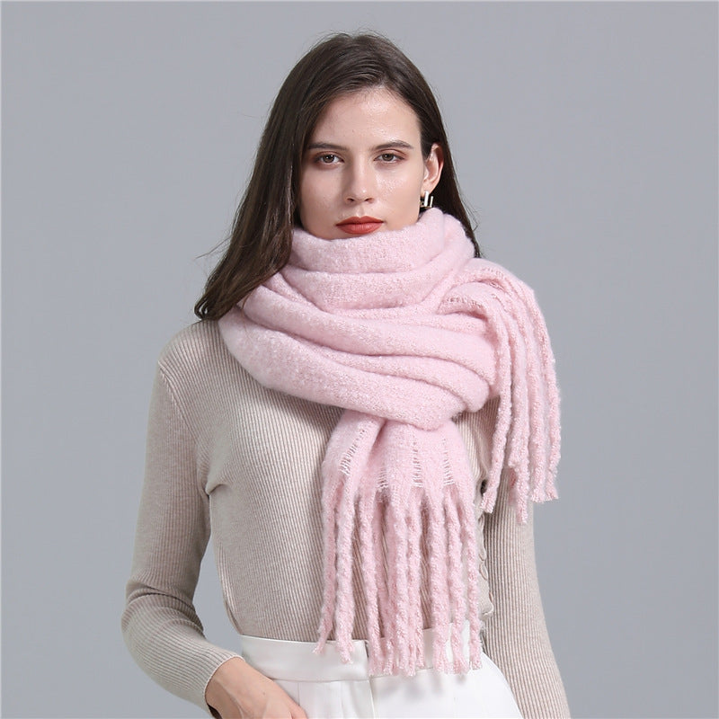 Woman wearing a pink scarf against a gray background