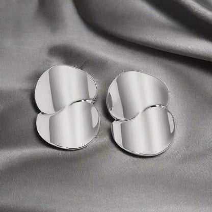 Stainless Steel Minimalist Geometric Curve Earrings on a silky gray background, reflecting contemporary elegance.