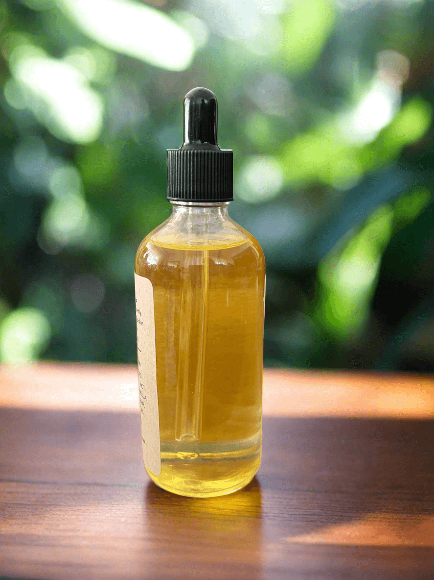 Bottle of yellow liquid with a dropper on a wooden surface with a blurred green background