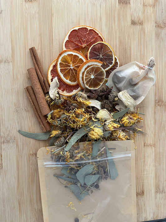 Seasonal Dry or Simmering Potpourris featuring dried fruits, herbs, and spices on a wooden background.