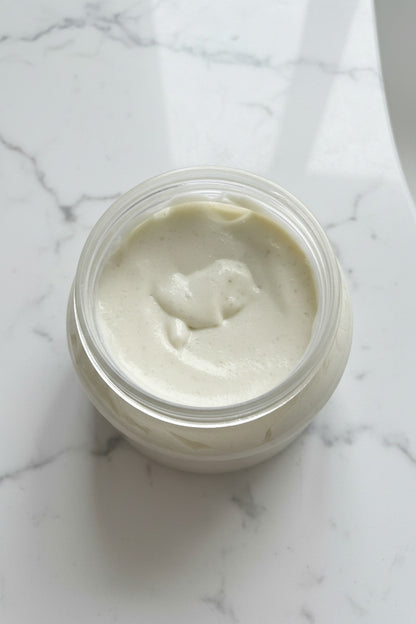 Container of white cream on a brown surface