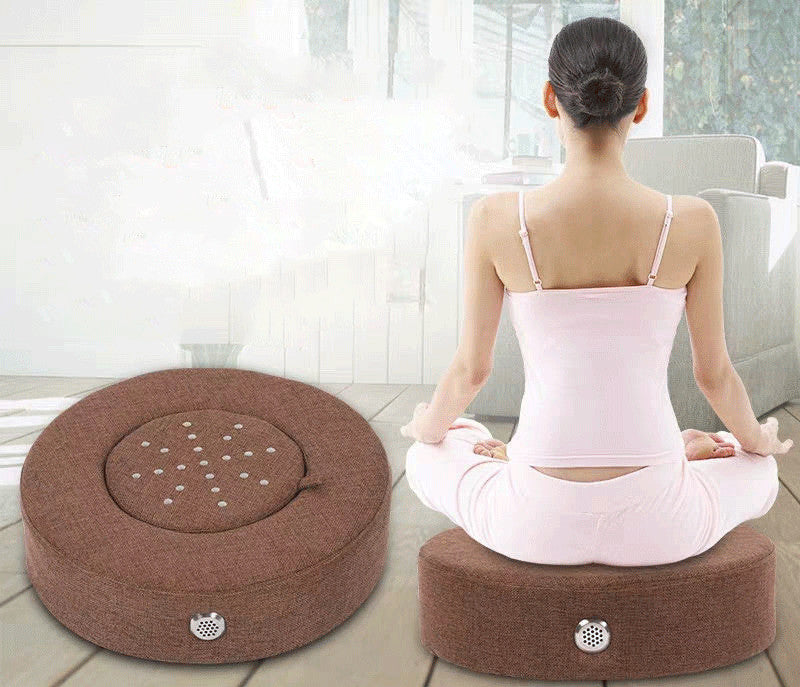 Person sitting on a meditation cushion in a bright room