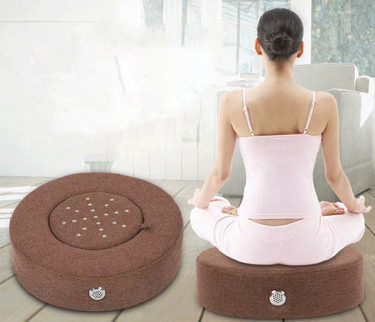 Person sitting on a meditation cushion in a bright room