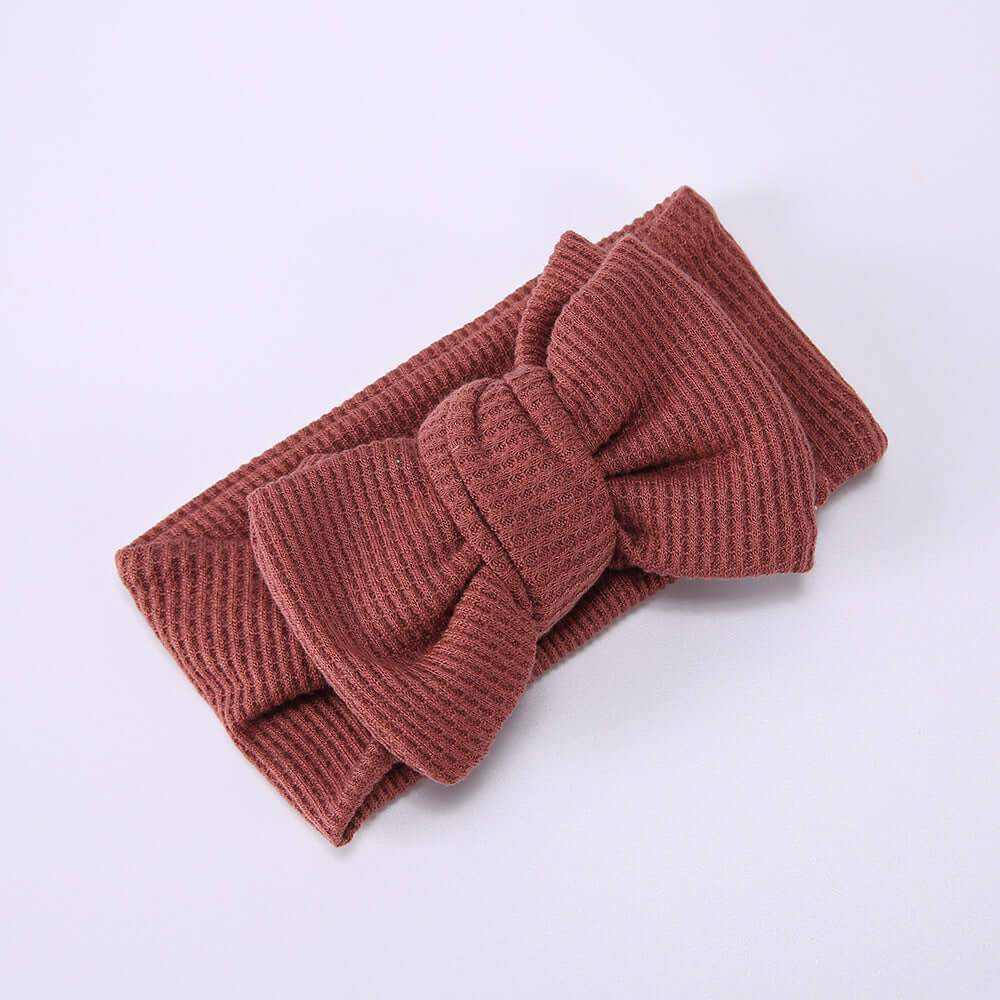 Children's Waffle Knit Oversized Bow Headband in cozy rust color, perfect for adding charm to little girls' outfits.